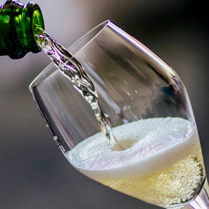 Champagne being poured into a glass, showcasing the effervescent bubbles.