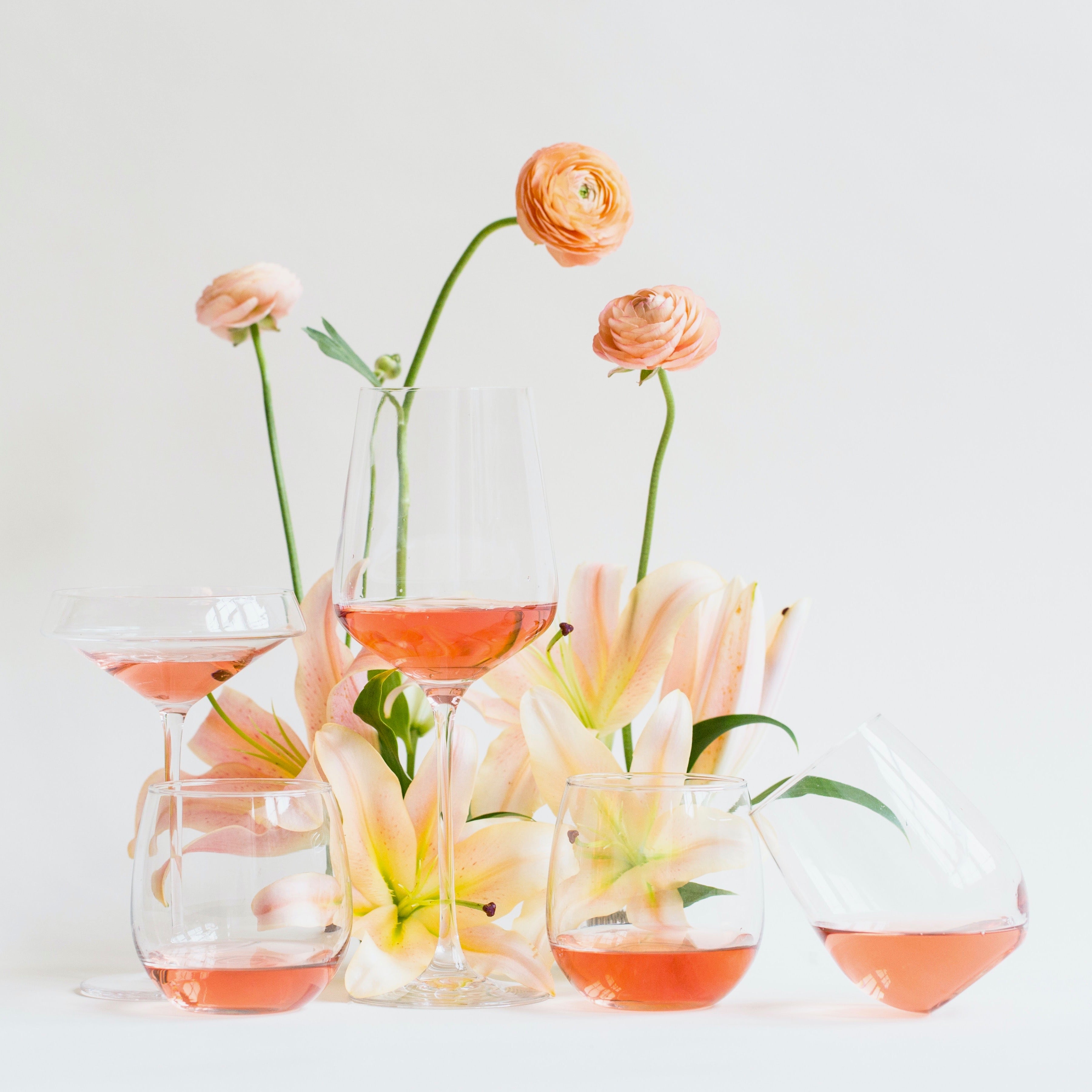 Elegant arrangement of rosé wine glasses with pink flowers, showcasing the beauty of rosé wines for tasting, wine education, and San Francisco Wine School events.