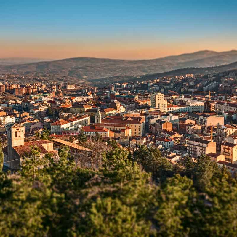 A hilltop view of a town with mountains in the distance in Molise